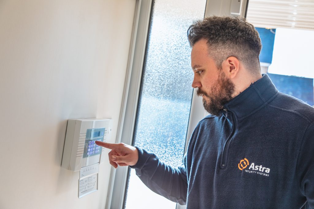 Astra Security Services employee installing an alarm. 